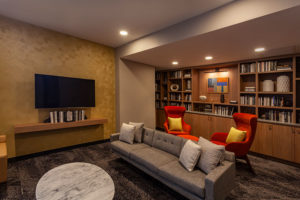Resident library with couch and tv at Chocolate Works apartments in Old City