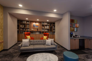 Resident library with TV, kitchen, and workstations at Chocolate Works apartments in Old City